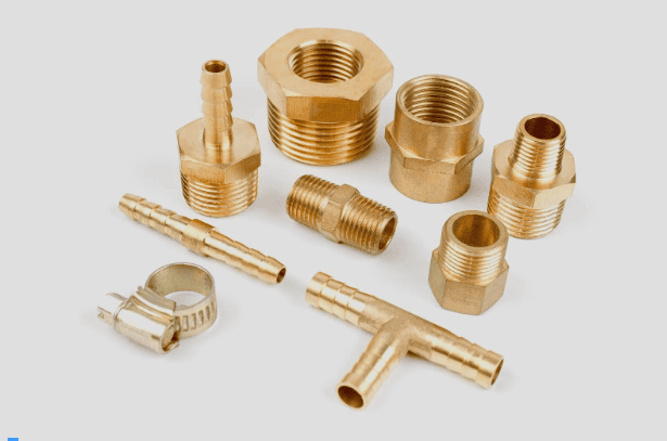 مجموعه‌ای از اتصالات برنجی شلنگ‌خور، رابط‌های رزوه‌دار و بست فلزی روی پس‌زمینه سفید.